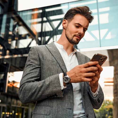 young business man in the office looking looking at his mobile phone
