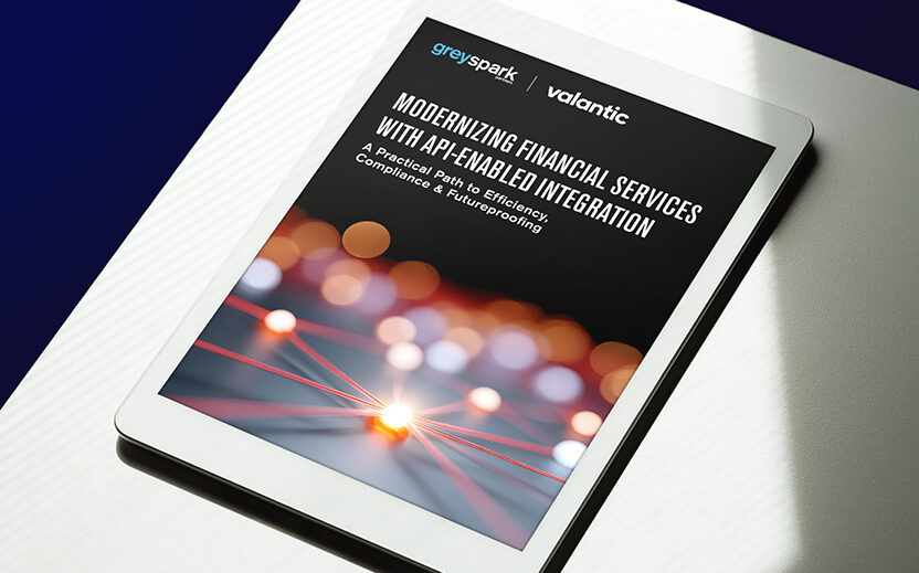 White tablet showing the title page of the greyspark-valantic FSA Report "Modernizing Financial Services with API-enabled integration", positioned on a white table with natural light and shadow